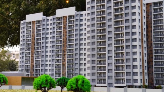 A modern multi-story residential building in Ahmedabad with white facade and numerous balconies.