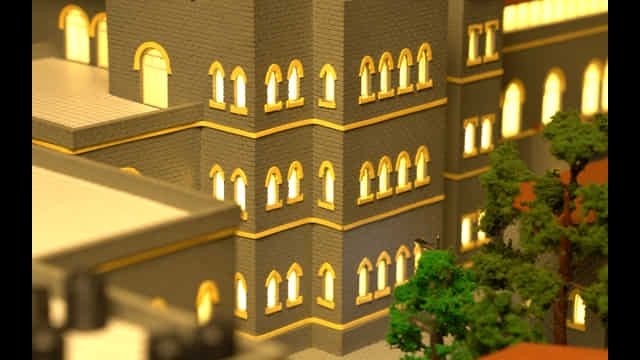 Beige hospital building model with illuminated windows at 63 St. George's Hospital, Mumbai.