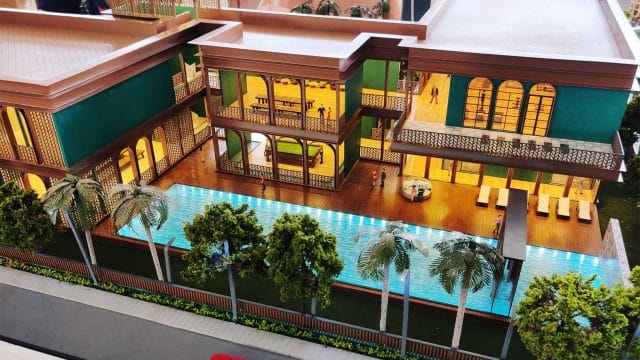 A lush residential complex with a swimming pool, surrounded by palm trees and modern architecture.