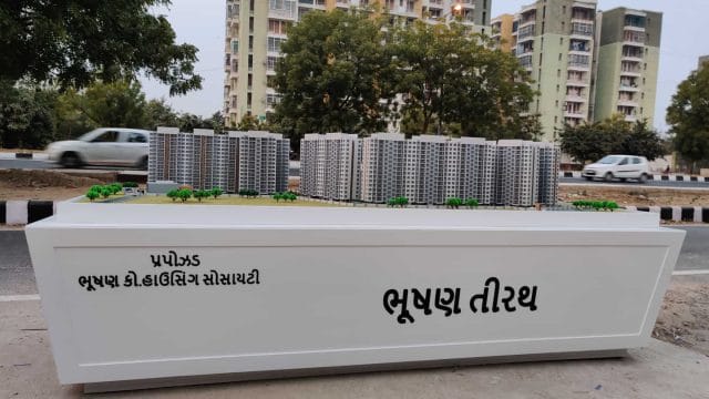 Beige Newt model display with residential buildings in the background, showcasing urban development.