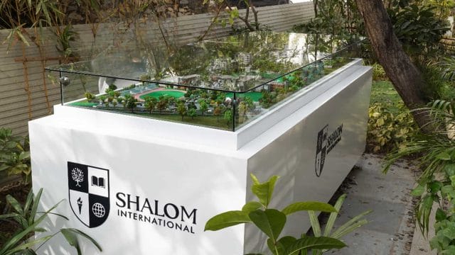 Beige Newt model displayed outdoors at Shalom International School, showcasing modern educational ar.