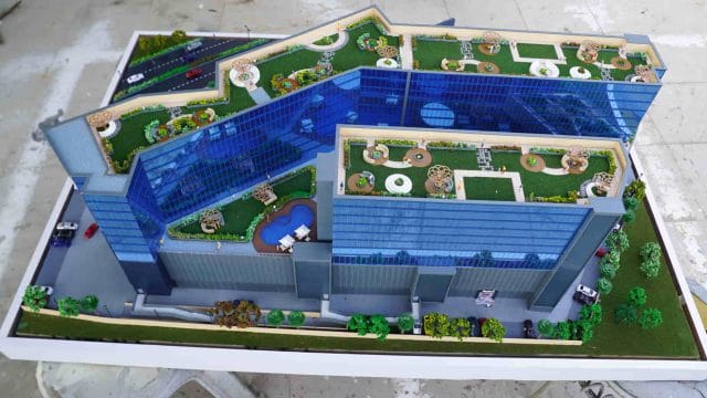 Modern architectural model of 64 GT South City exhibition complex with landscaped gardens and roofto.