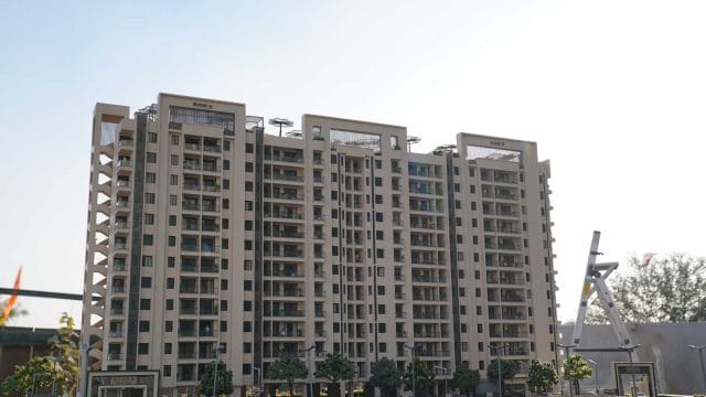 Beige modern residential building at 66 Alaya by GBD Group, featuring multiple balconies and contemp.