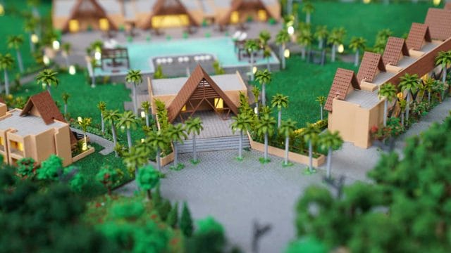 Model of a tropical resort with traditional-style villas and lush greenery.