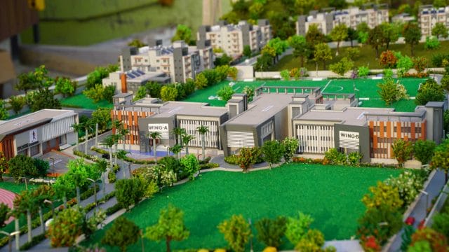 Detailed model of 62 Shalom International School campus with greenery and sports facilities.