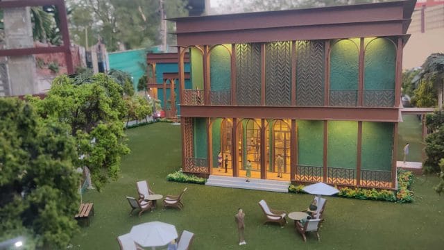 Modern two-story clubhouse at 68 Mangalam Rambhag Club with lush garden and outdoor seating area.