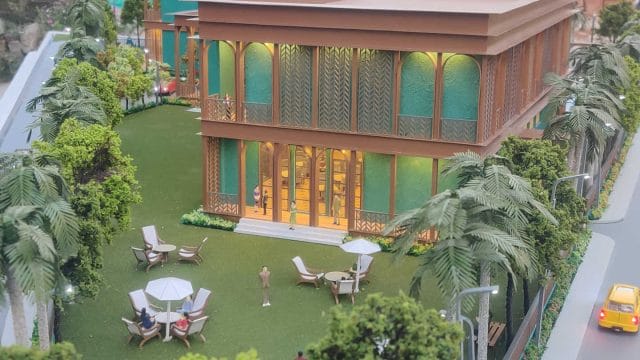 Beige Newt model house with lush garden and outdoor seating area at 68 Mangalam Rambhag Club.